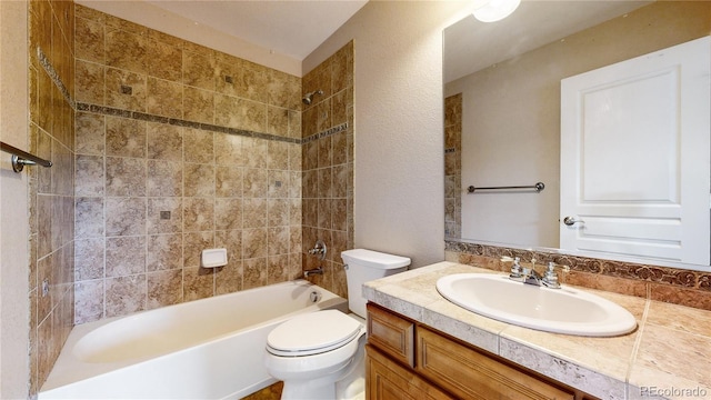 full bathroom featuring vanity, tiled shower / bath combo, and toilet