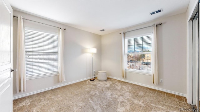 spare room featuring light colored carpet