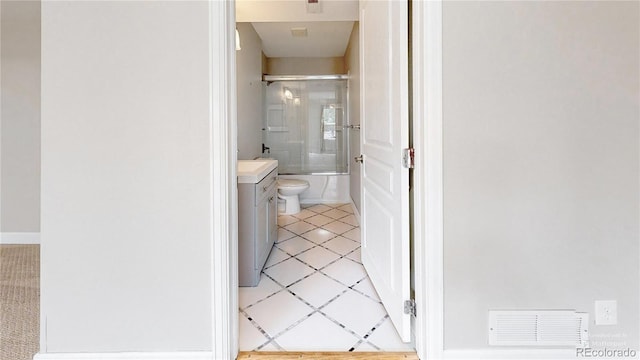 full bathroom featuring vanity, toilet, and bath / shower combo with glass door