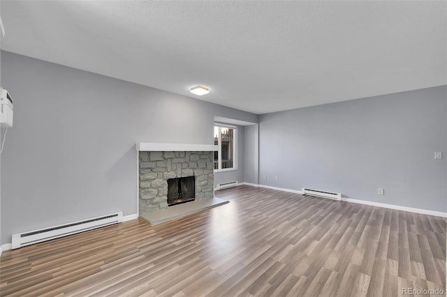 unfurnished living room featuring a baseboard radiator, baseboards, and wood finished floors