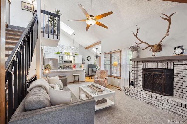 living area featuring ceiling fan, a brick fireplace, high vaulted ceiling, carpet floors, and plenty of natural light