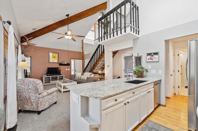 kitchen featuring a sink, appliances with stainless steel finishes, ceiling fan, a peninsula, and white cabinets