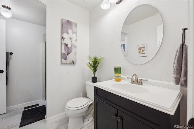 full bathroom with toilet, vanity, baseboards, and a shower with door