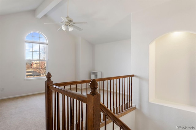 hall with carpet, baseboards, lofted ceiling with beams, and an upstairs landing