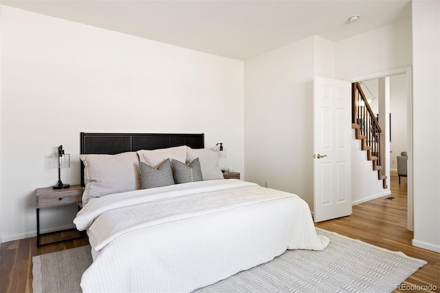 bedroom with baseboards and wood finished floors