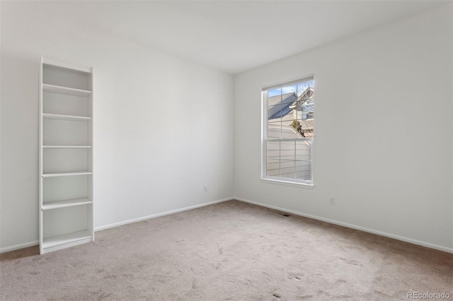 carpeted empty room with baseboards