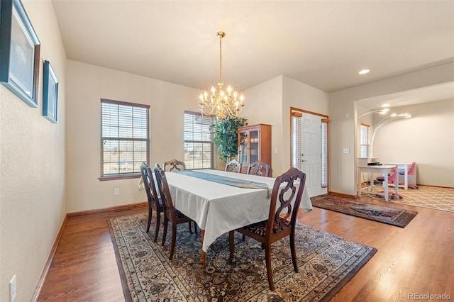 dining space with hardwood / wood-style flooring and an inviting chandelier