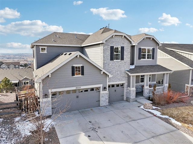 craftsman inspired home featuring a porch, a garage, stone siding, driveway, and roof with shingles