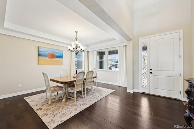 dining space featuring a chandelier, a raised ceiling, baseboards, and dark wood-style flooring