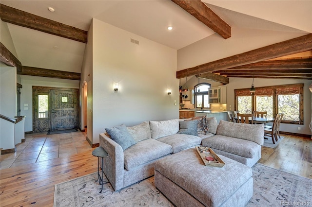 living room featuring lofted ceiling with beams and wood-type flooring