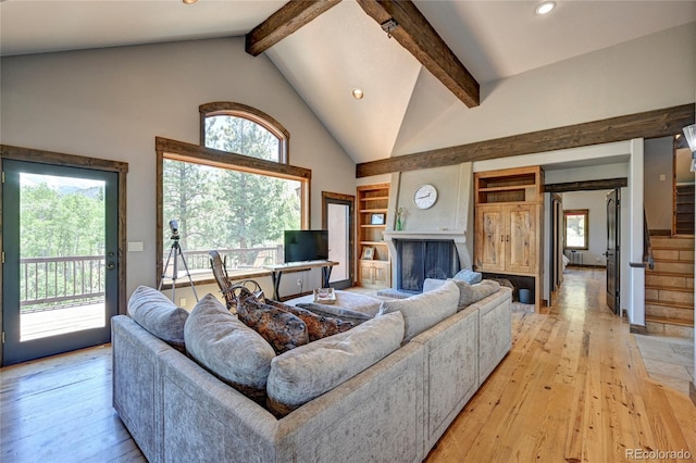 living room with light hardwood / wood-style floors, high vaulted ceiling, and plenty of natural light