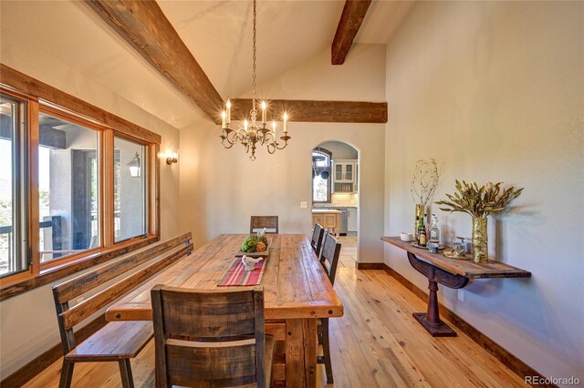 dining area featuring high vaulted ceiling, light hardwood / wood-style flooring, a notable chandelier, and beam ceiling