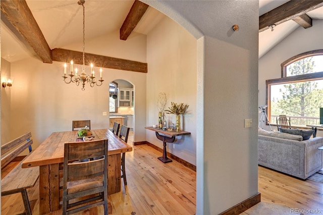 dining room with high vaulted ceiling, beamed ceiling, a chandelier, and light hardwood / wood-style floors