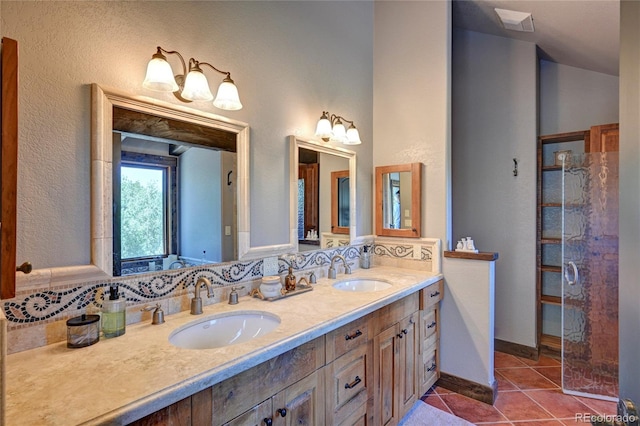 bathroom with a shower with door, tile patterned flooring, and dual bowl vanity