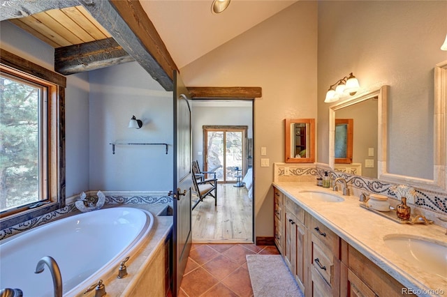 bathroom with double vanity, hardwood / wood-style flooring, vaulted ceiling, and plenty of natural light