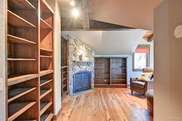 unfurnished living room featuring light hardwood / wood-style floors, a fireplace, and vaulted ceiling