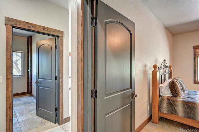 hallway featuring a textured ceiling and light tile patterned floors