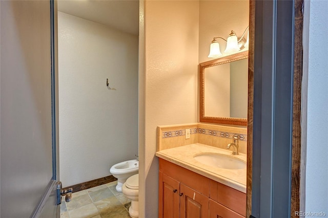 bathroom with tile patterned floors, toilet, a bidet, and vanity