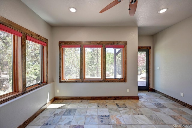 tiled empty room featuring a textured ceiling and ceiling fan