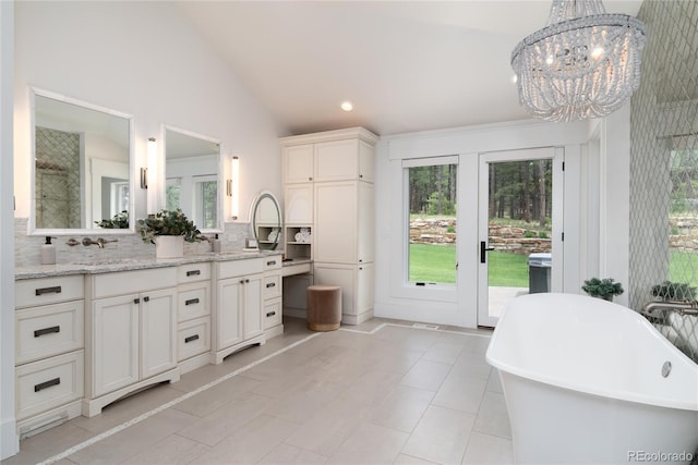 44 N Big Meadow Trl, Franktown, CO 80116 - bathroom with a soaking tub, double vanity, a chandelier, decorative backsplash, and lofted ceiling