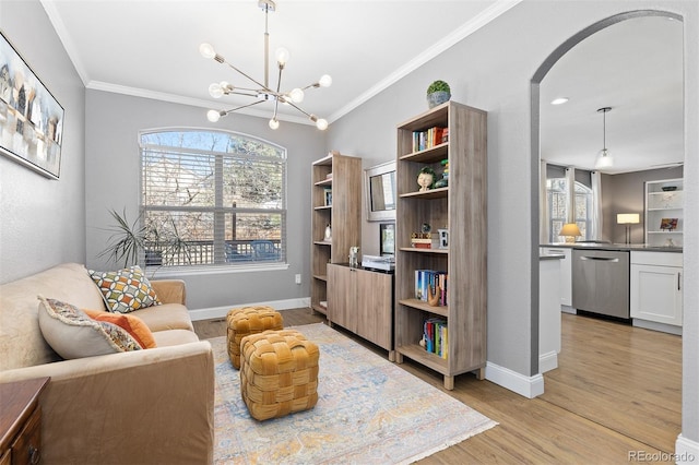 living area with arched walkways, a notable chandelier, baseboards, light wood-type flooring, and crown molding