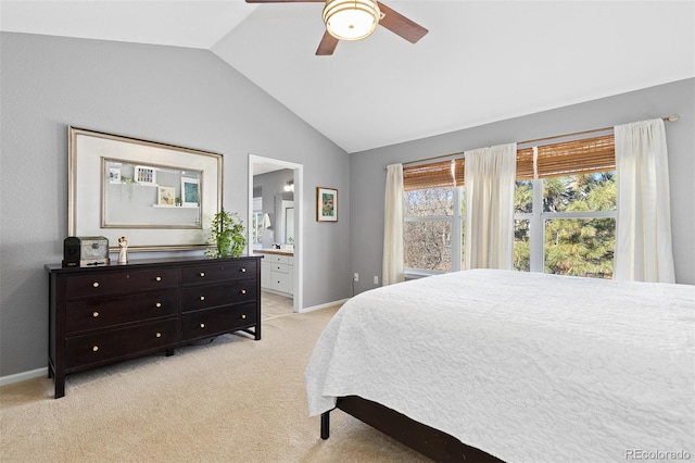 bedroom featuring lofted ceiling, light colored carpet, a ceiling fan, ensuite bath, and baseboards