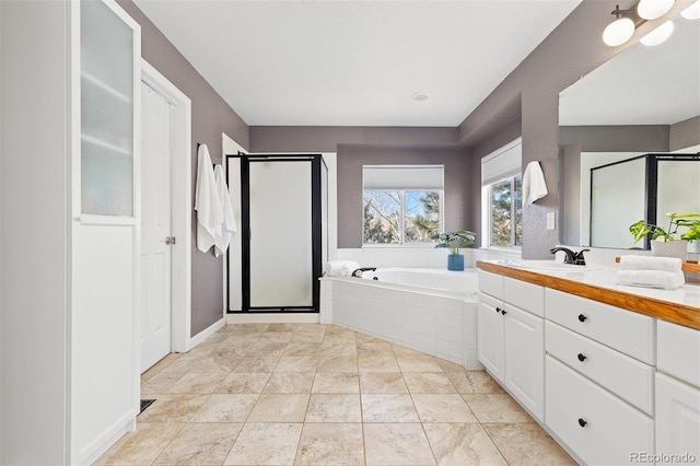 bathroom with a stall shower, tile patterned flooring, a garden tub, and vanity