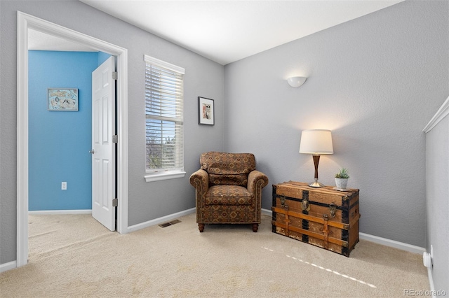 living area featuring baseboards, visible vents, and carpet flooring