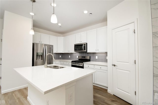 8376 Lorenzo Ln Unit A, Highlands Ranch, CO 80129 - kitchen with appliances with stainless steel finishes, wood finished floors, decorative backsplash, an island with sink, and recessed lighting