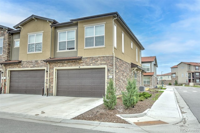 8376 Lorenzo Ln Unit A, Highlands Ranch, CO 80129 - view of front of house with stucco siding, an attached garage, stone siding, and driveway