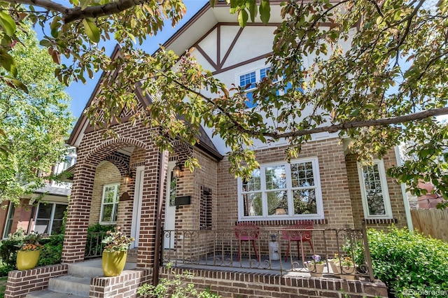 tudor house featuring fence and brick siding