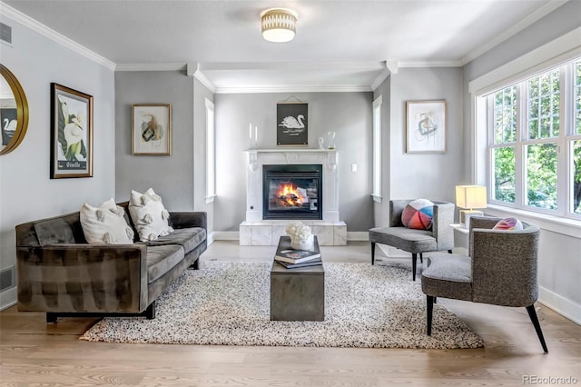 living room with visible vents, ornamental molding, wood finished floors, baseboards, and a premium fireplace