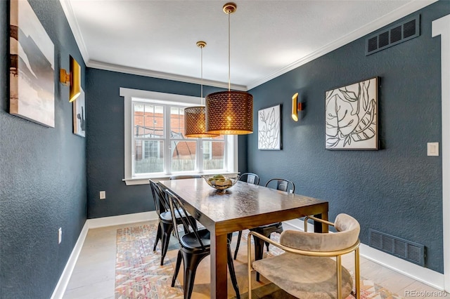 dining room with visible vents, crown molding, baseboards, and a textured wall