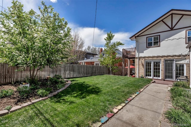 view of yard featuring a fenced backyard and a balcony