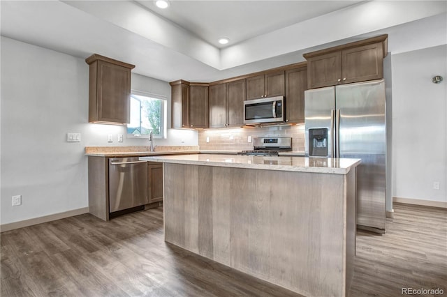 32 Trailside Cir Unit A, Salida, CO 81201 - kitchen with appliances with stainless steel finishes, dark wood-style floors, a center island, baseboards, and tasteful backsplash