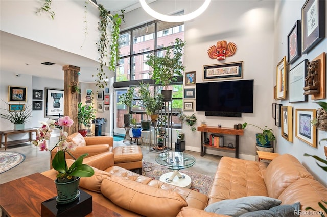 930 Acoma St Unit 106, Denver, CO 80204 - living room with a high ceiling, finished concrete flooring, and decorative columns