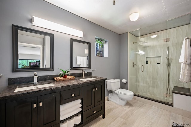 930 Acoma St Unit 106, Denver, CO 80204 - bathroom featuring wood finished floors, a shower stall, toilet, and double vanity
