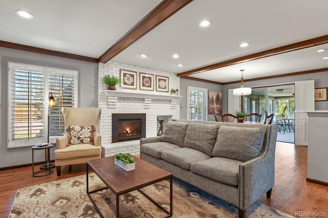 living area featuring plenty of natural light, beamed ceiling, and wood finished floors