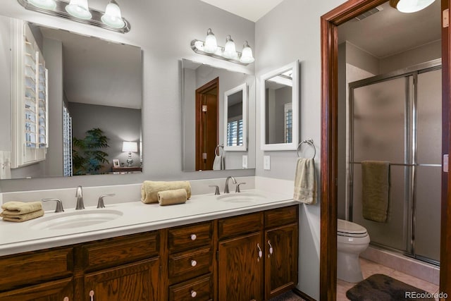 full bath with toilet, a stall shower, tile patterned flooring, and a sink