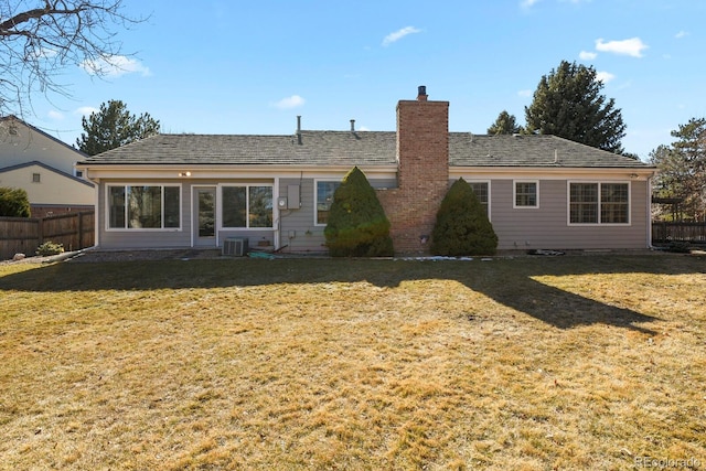 back of property featuring a yard, a chimney, cooling unit, and fence