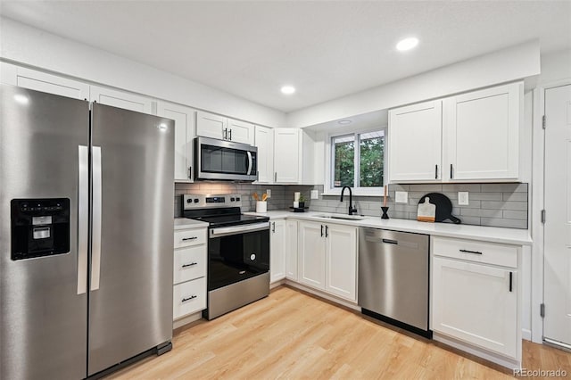 11176 W 62nd Ave, Arvada, CO 80004 - kitchen with appliances with stainless steel finishes, light countertops, light wood finished floors, tasteful backsplash, and recessed lighting