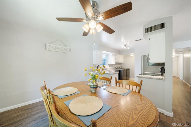 dining room featuring washing machine and dryer, dark hardwood / wood-style floors, sink, and ceiling fan