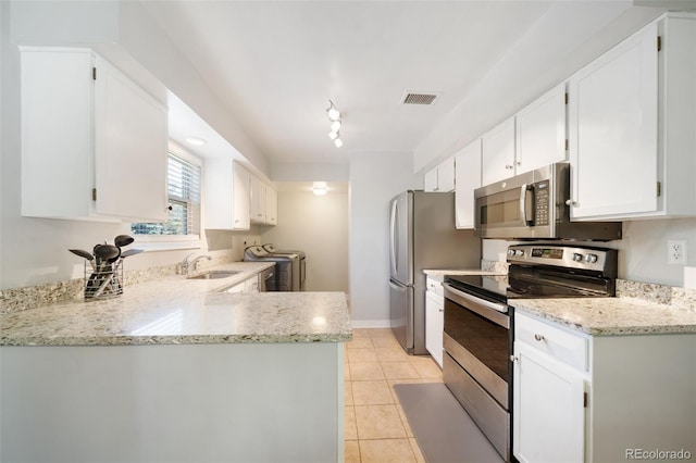 kitchen featuring light stone counters, stainless steel appliances, and white cabinets