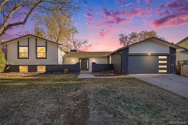 tri-level home with a yard and a garage