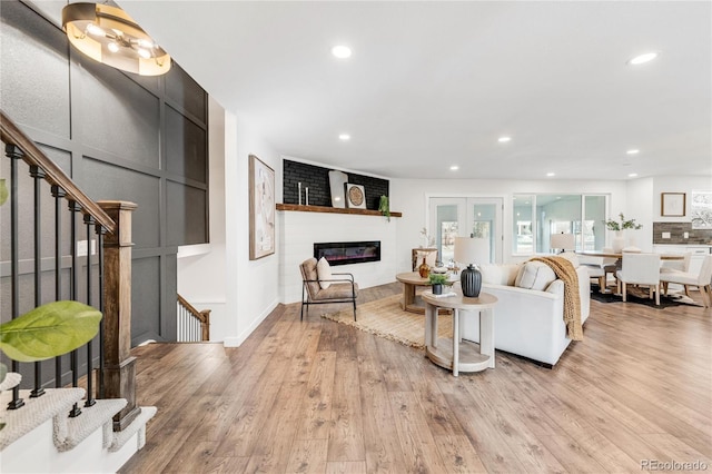 living room with a fireplace and light wood-type flooring