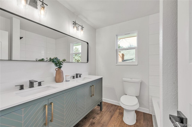 bathroom with hardwood / wood-style floors, vanity, toilet, and a wealth of natural light