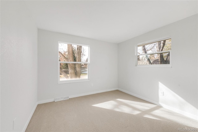 carpeted empty room with a wealth of natural light