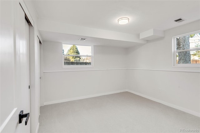 basement with light colored carpet and a wealth of natural light