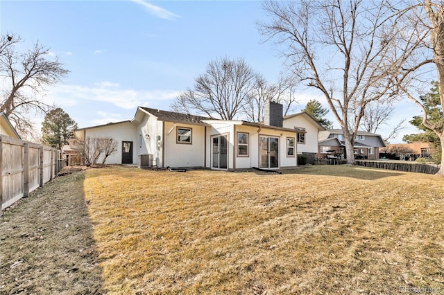 back of property featuring a lawn and central AC