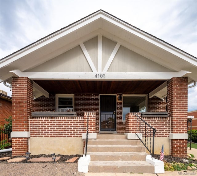 view of front of home featuring a porch and brick siding